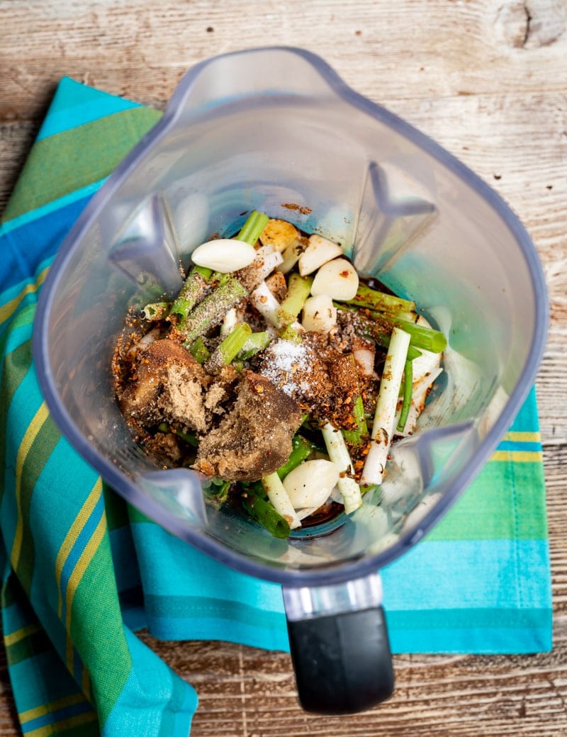 prep image of a close up of blender with jerk seasoning ingredients in it, aqua striped napkin