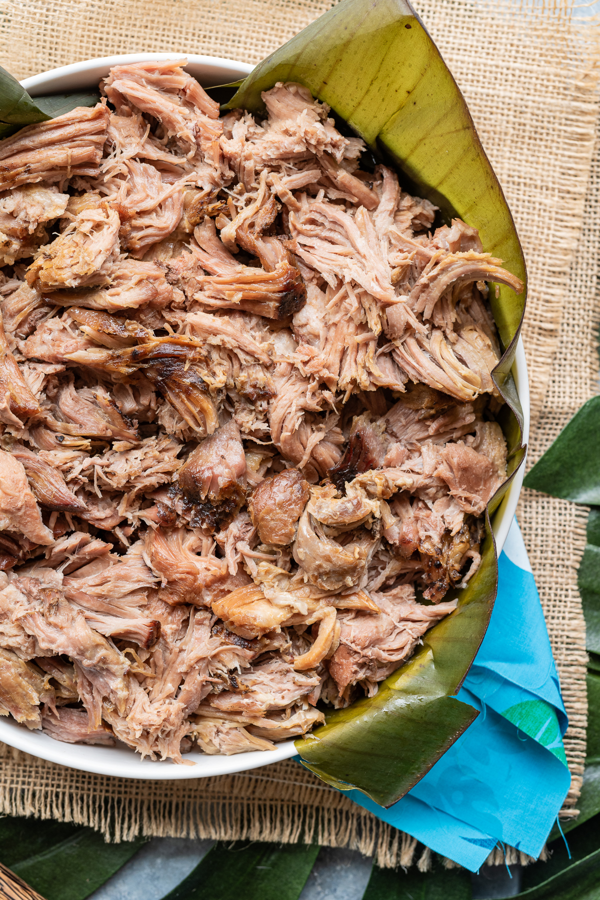 kālua pork in a serving platter with banana leaves