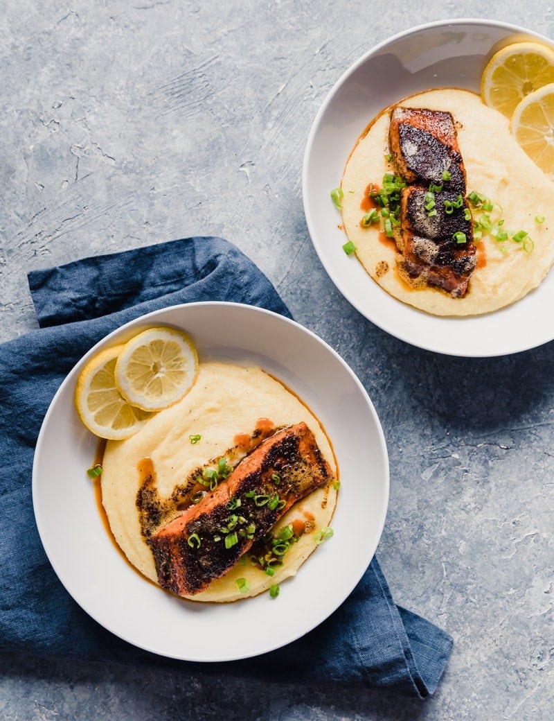 wild alaskan sockeye salmon served over cheddar cheese grits with lemon slices