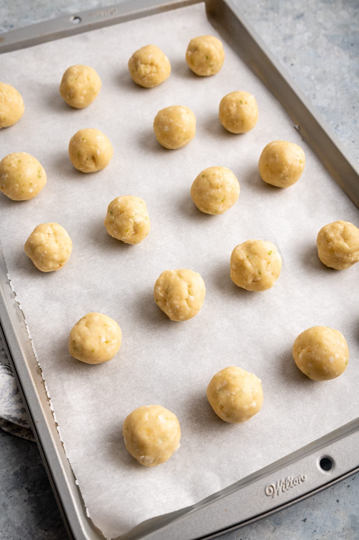 cookie dough balls on a baking sheet lined with parchment paper