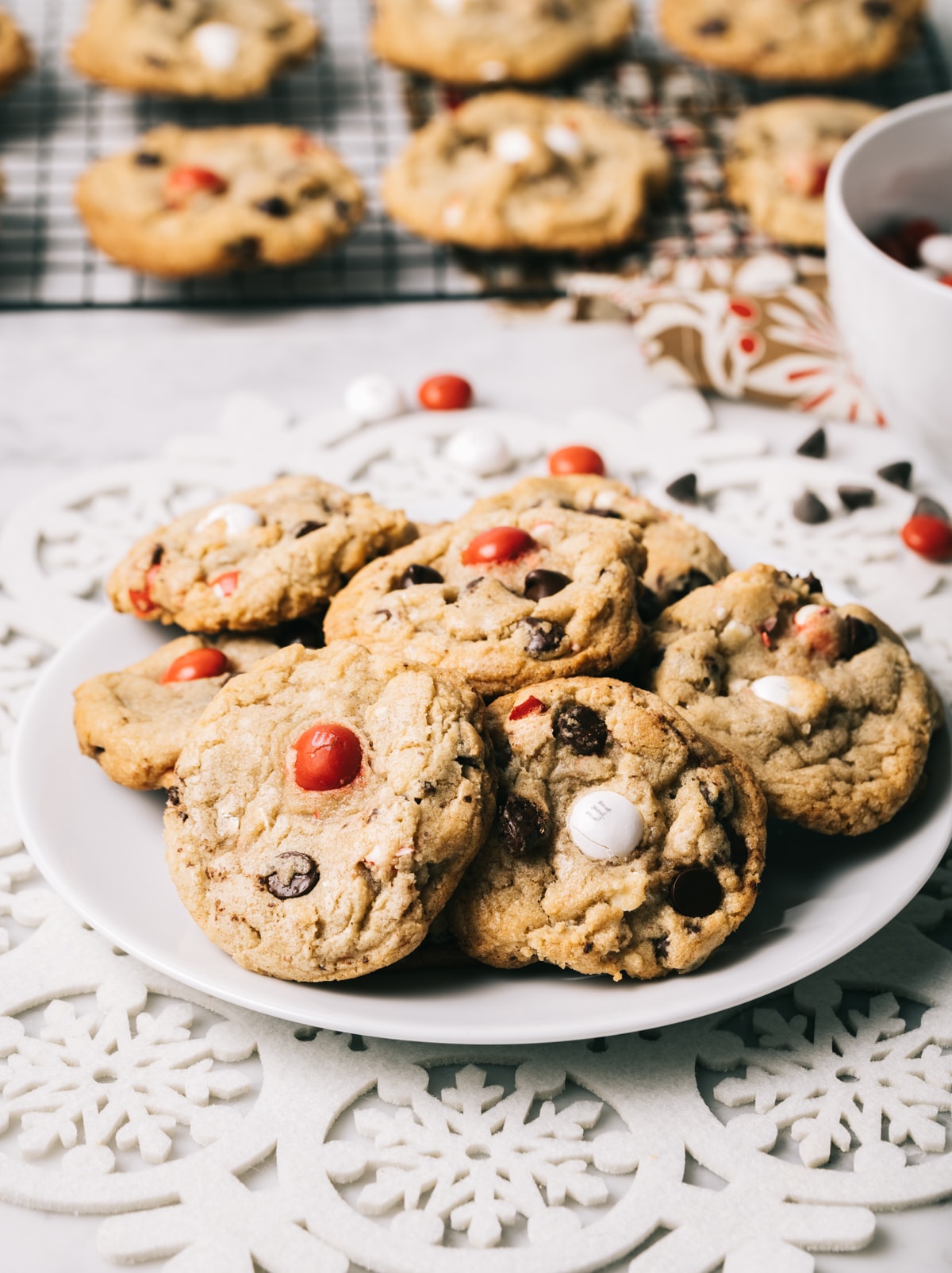 chocolate chip cookies with red and white M&M candies on a white plate