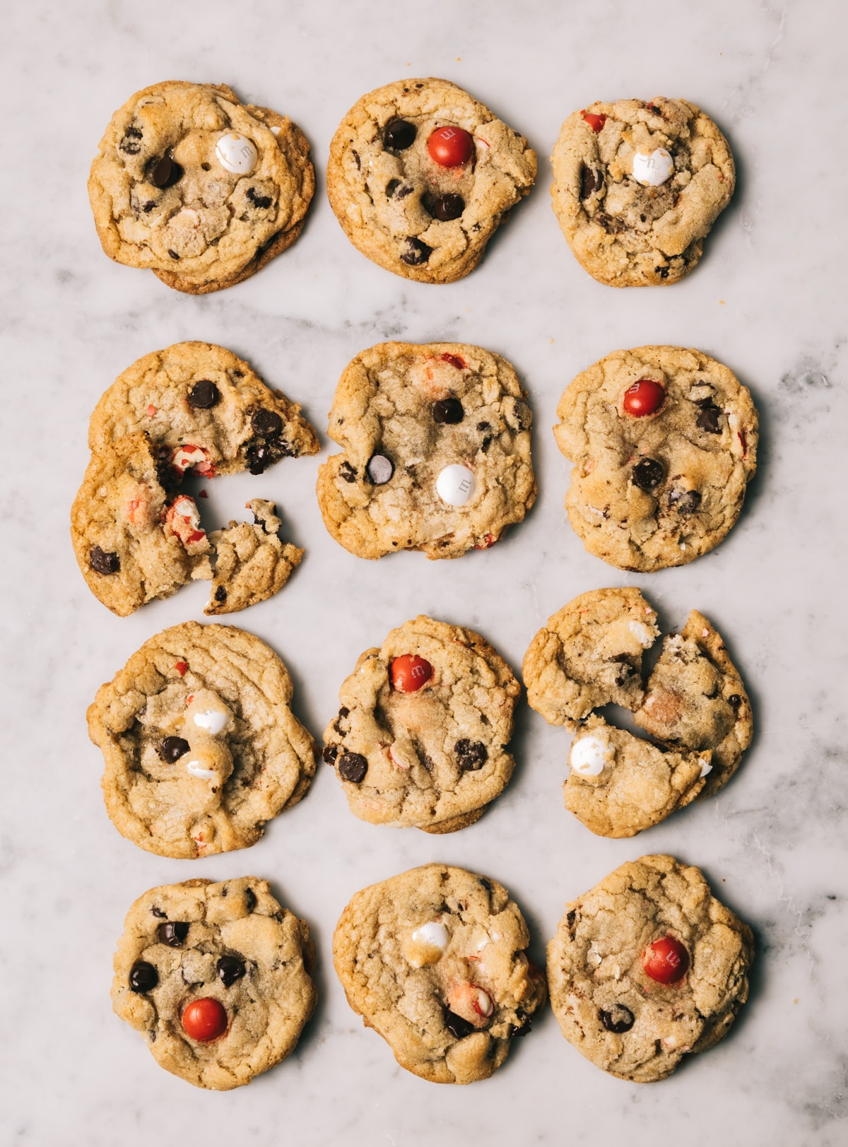 chocolate chip cookies with red and white M&M candies on a white marble surface