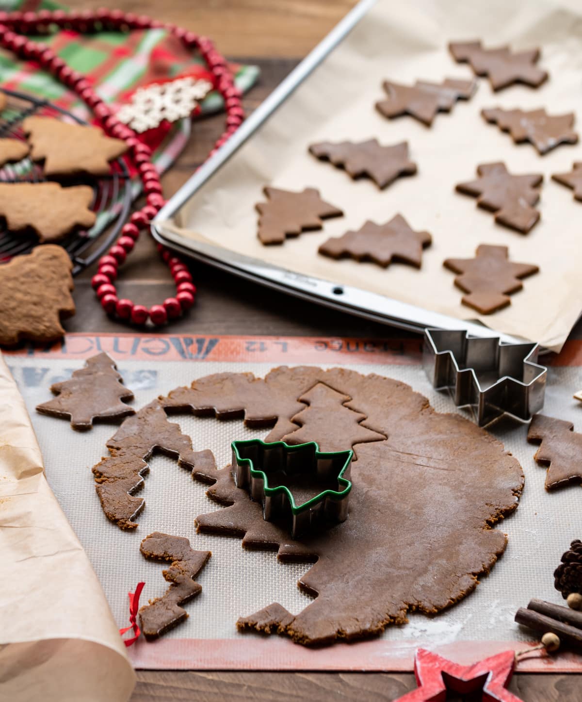gingerbread cookie dough with Christmas tree shaped cookie cutter, cut out cookies on a baking tray