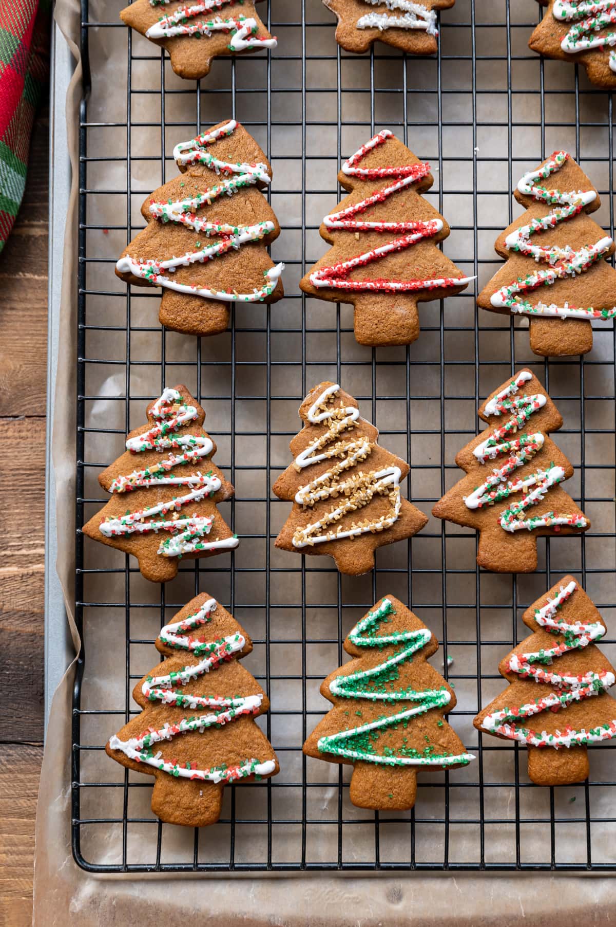 gingerbread cut out cookies on a wire rack with icing and colored sugar