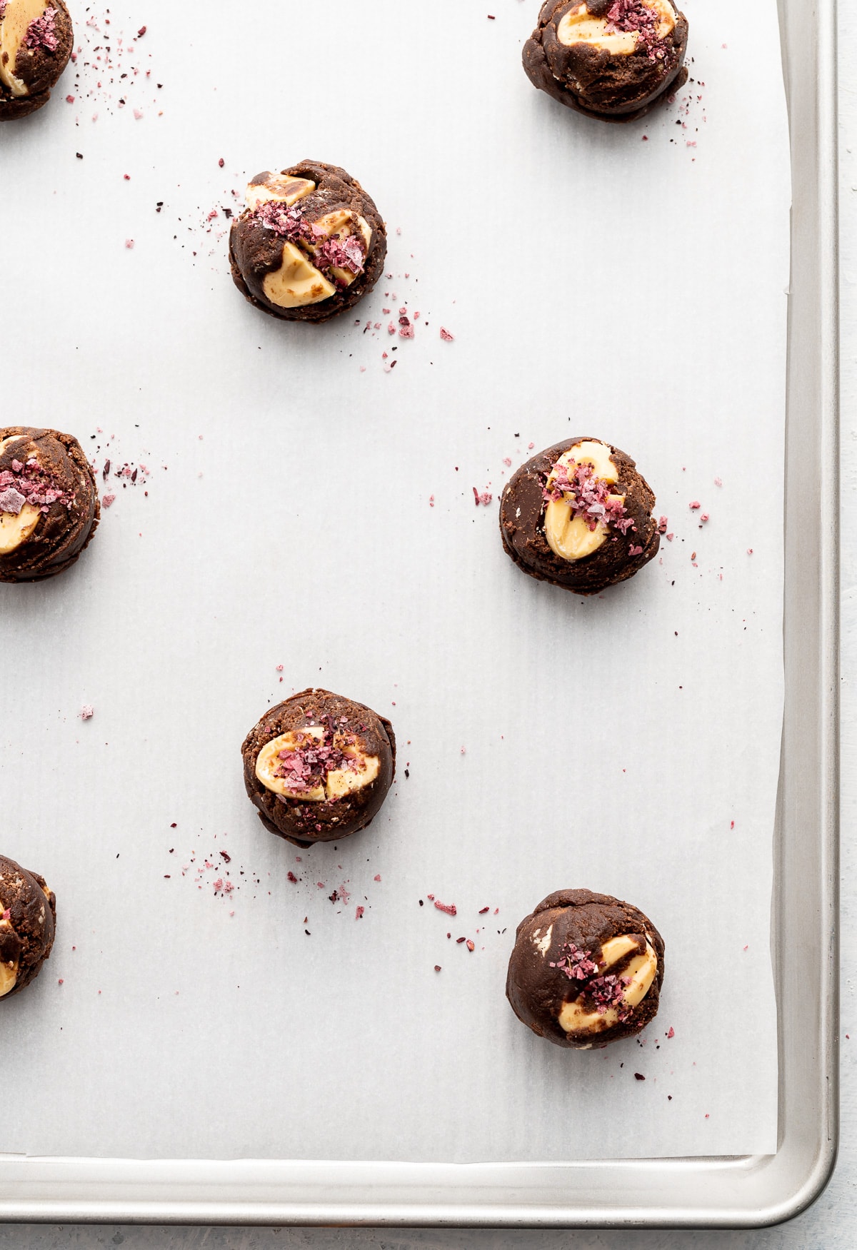 dark chocolate cookie dough balls with yellow passion fruit wafers and red hibiscus salt