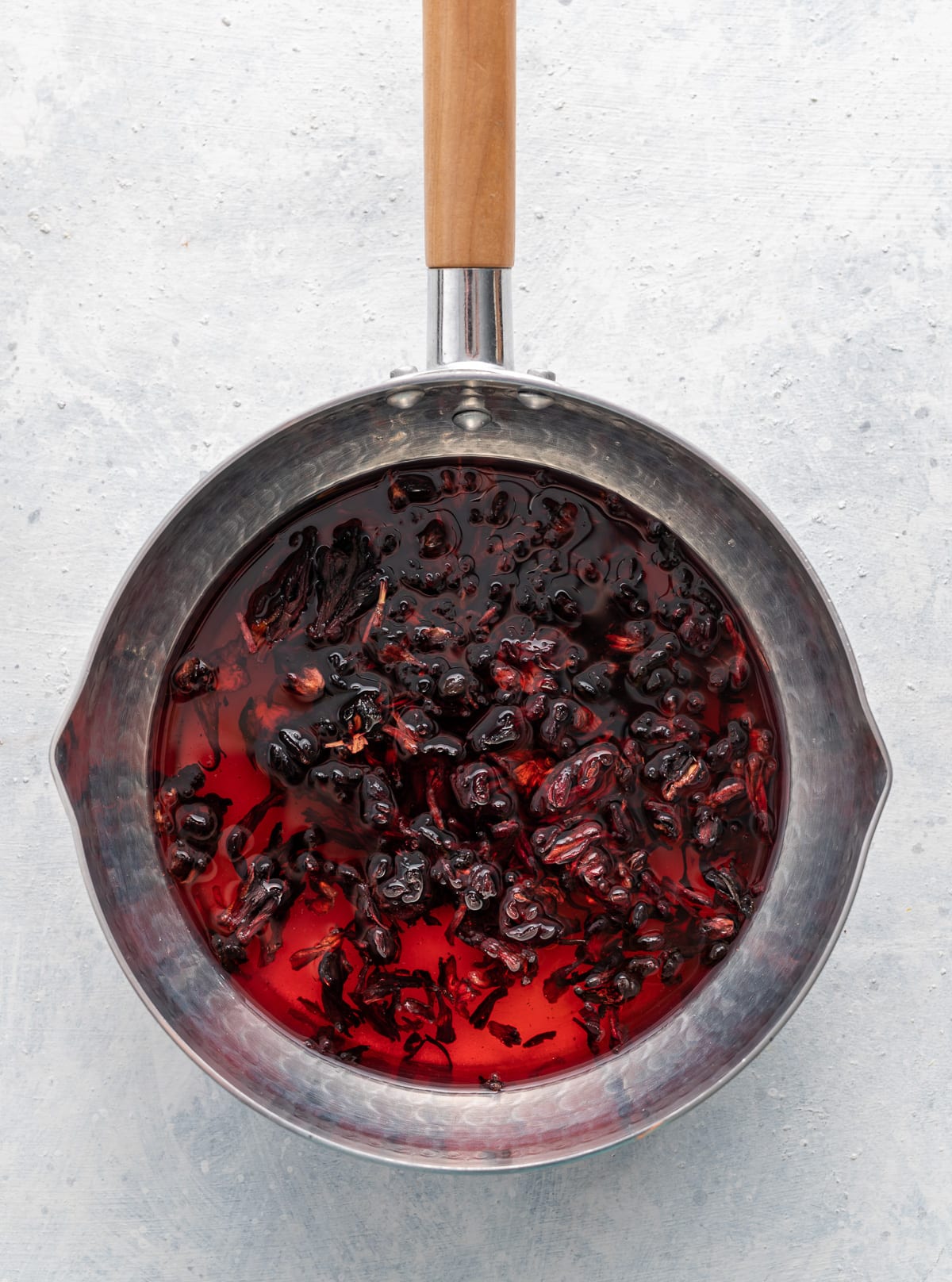 dark red hibiscus syrup in a pan