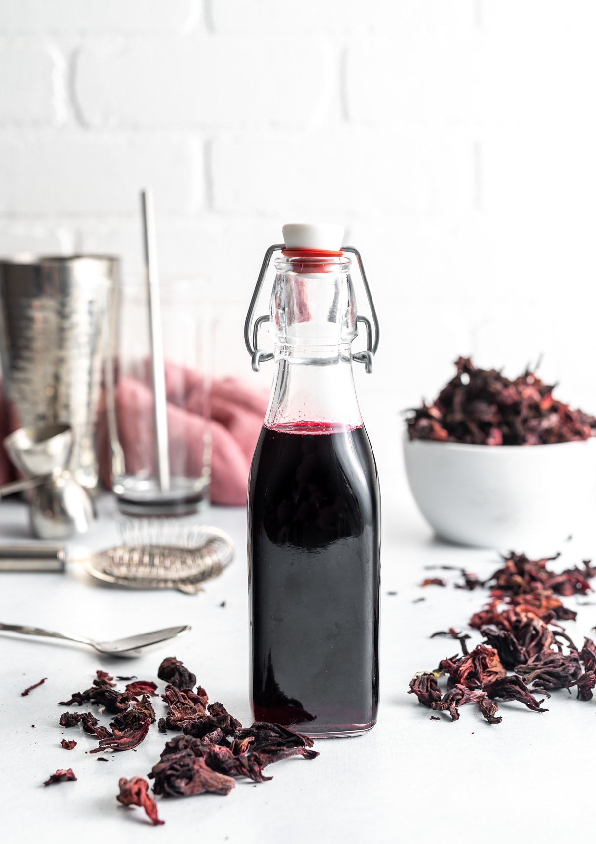 dark red hibiscus syrup in a bottle, dried hibiscus flowers