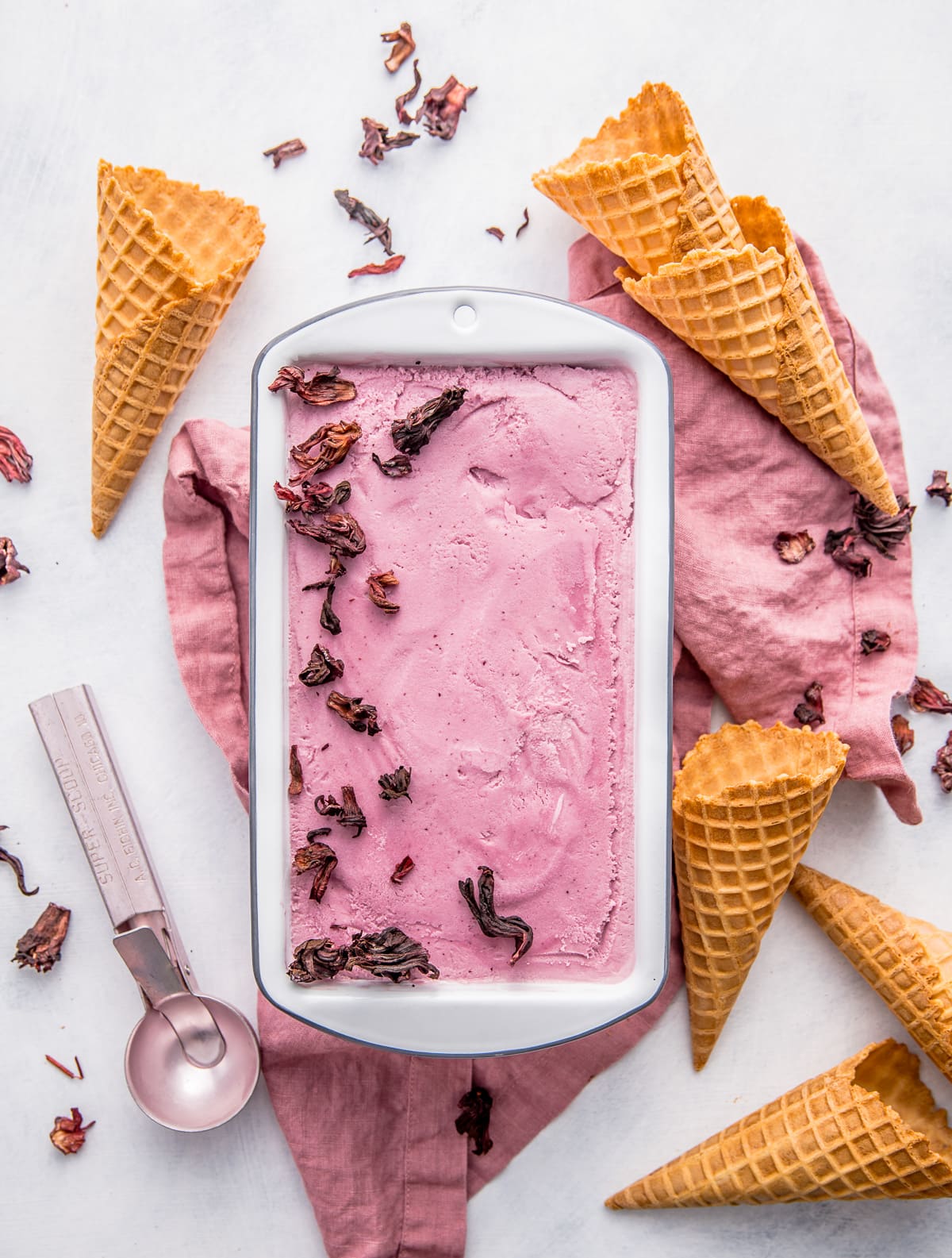 pink ice cream with dried hibiscus flowers and waffle ice cream cones