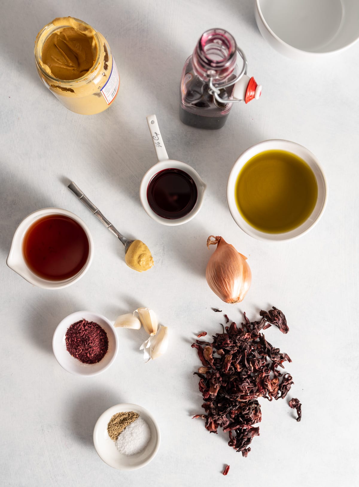 various bowls of ingredients oil vinegar hibiscus syrup shallot garlic dijon mustard