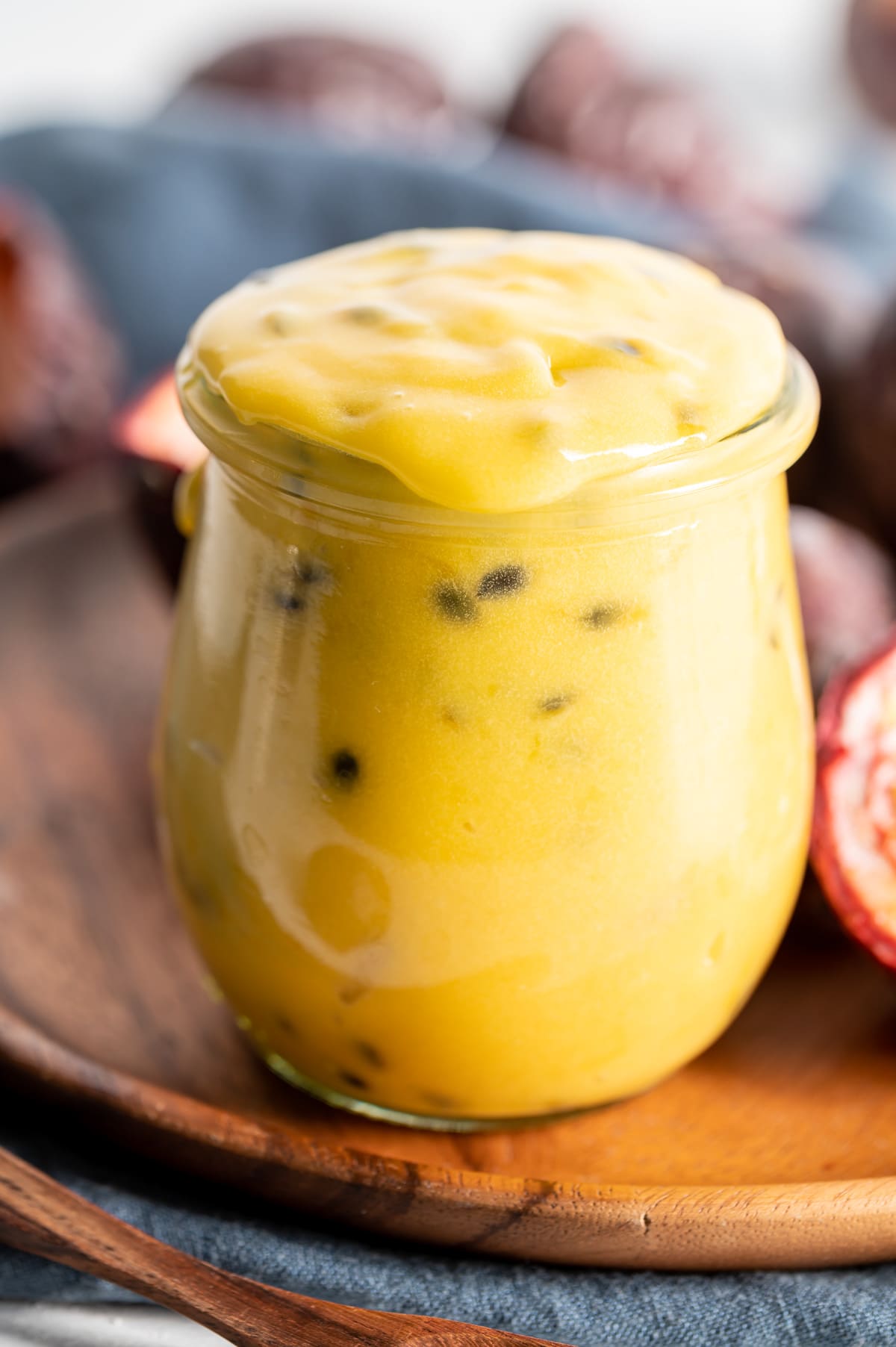 yellow passion fruit curd in a jar on brown plate