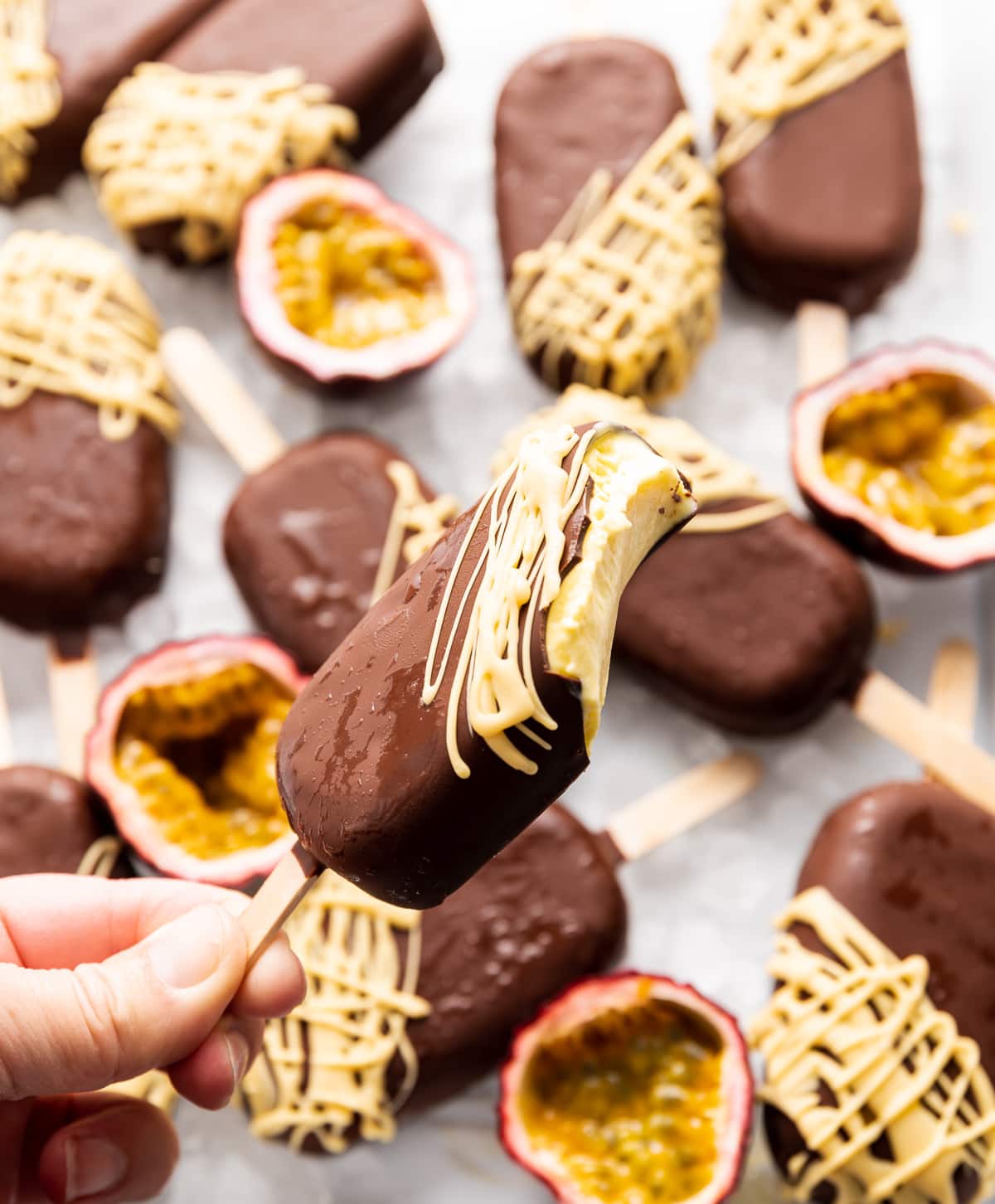 chocolate covered ice cream pops fresh passion fruits cut in half ice cream bar with a bite taken out of it