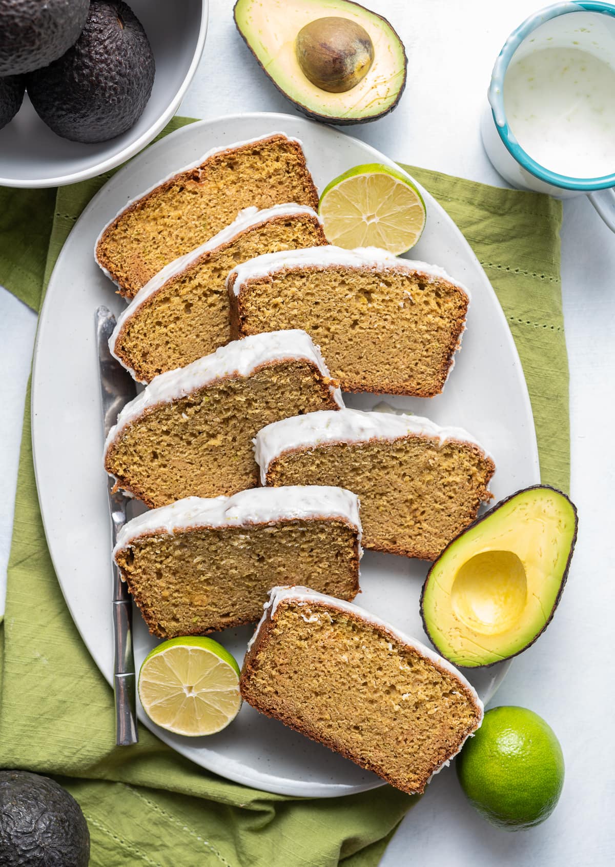 slices of glazed avocado bread with limes and sliced avocado