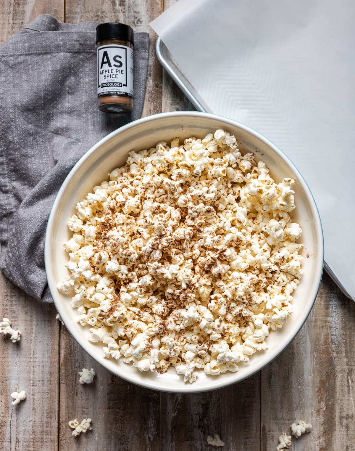 large white bowl filled with popped popcorn sprinkled with brown apple pie spice