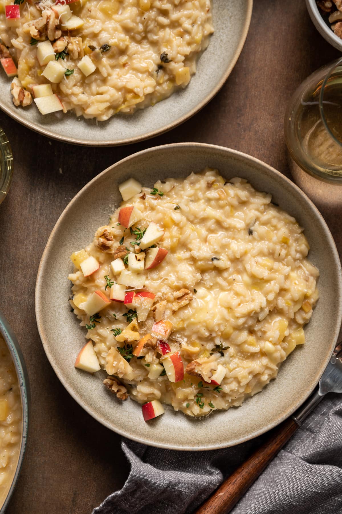 bowl of yellow brie risotto with apples walnuts and fresh thyme