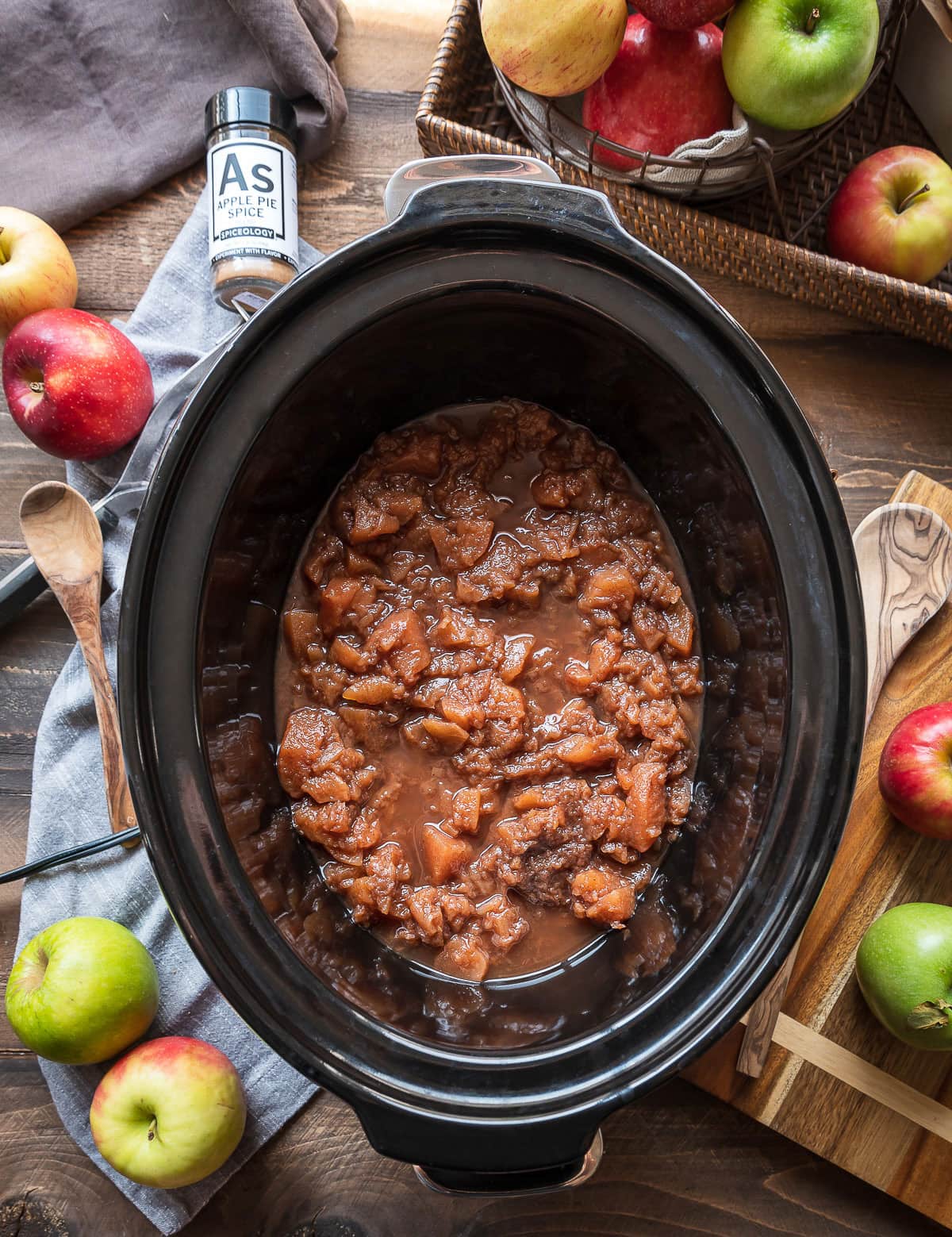  cooked apples in a slow cooker jar of spice whole apples with apples in a basket