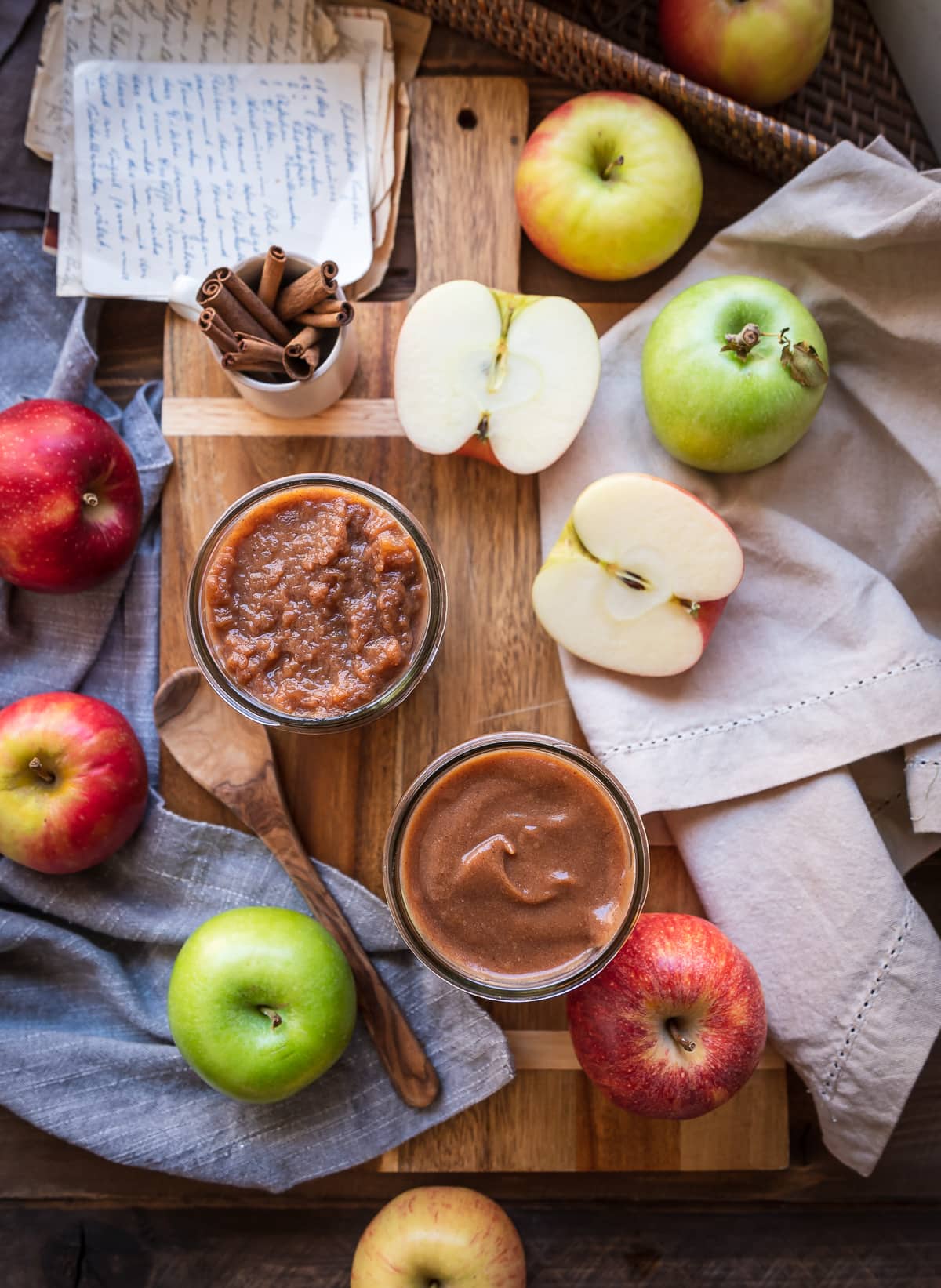 caramel brown slow cooker apple butter in jars whole apples napkins spoon whole cinnamon sticks