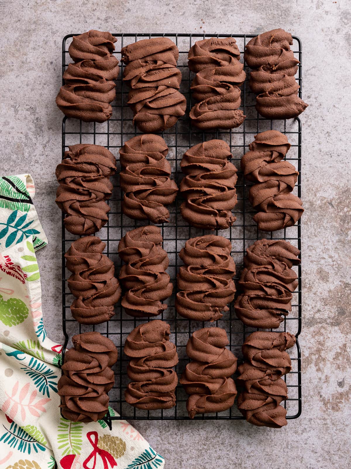 chocolate viennese butter cookies piped in a squiggle on a wire rack