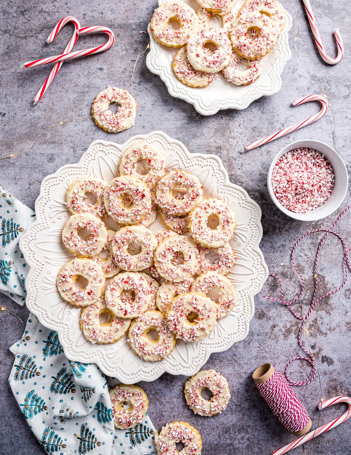wreath shaped peppermint shortbread cookies on a white plate candy canes bowl of candy cane pieces