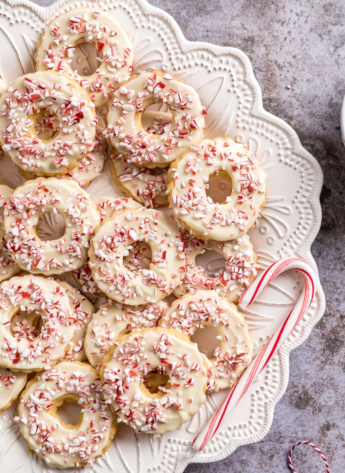 wreath shaped peppermint shortbread cookies on a white plate candy canes bowl of candy cane pieces