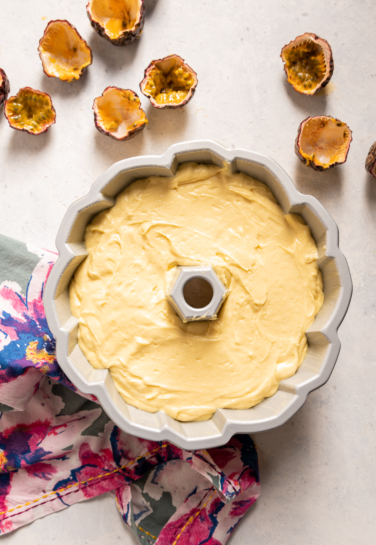 yellow cake batter in a bundt pan passionfruit halves