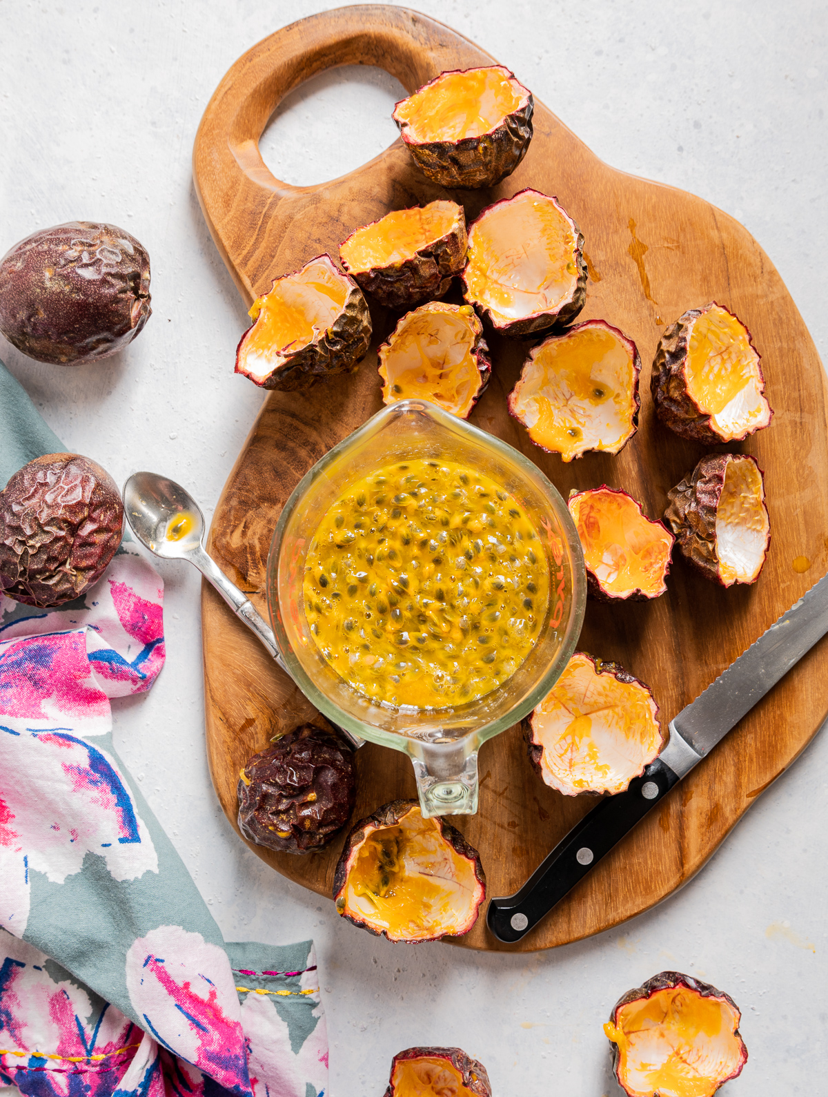 measuring cup full of passion fruit juice and seeds passion fruit shells cut in half