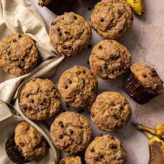 muffins in brown paper liners with chocolate chips tan napkin spotted bananas