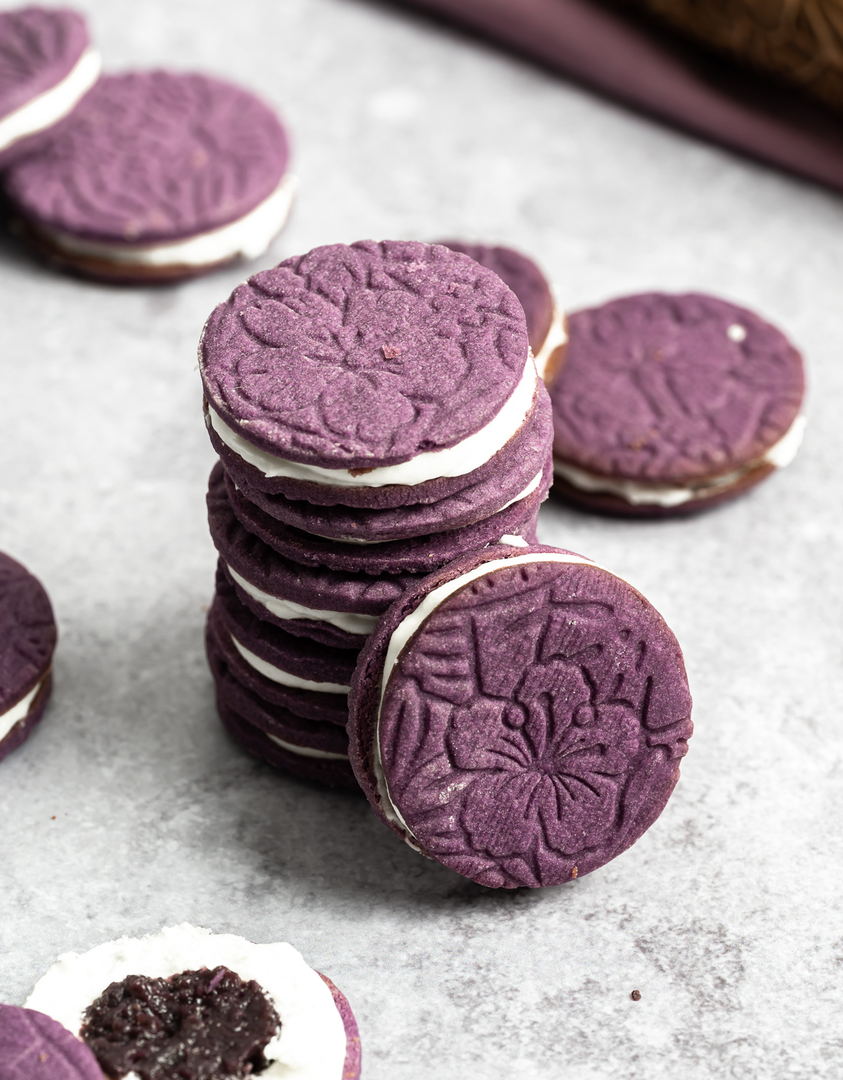 stack of purple sandwich cookies with white coconut frosting