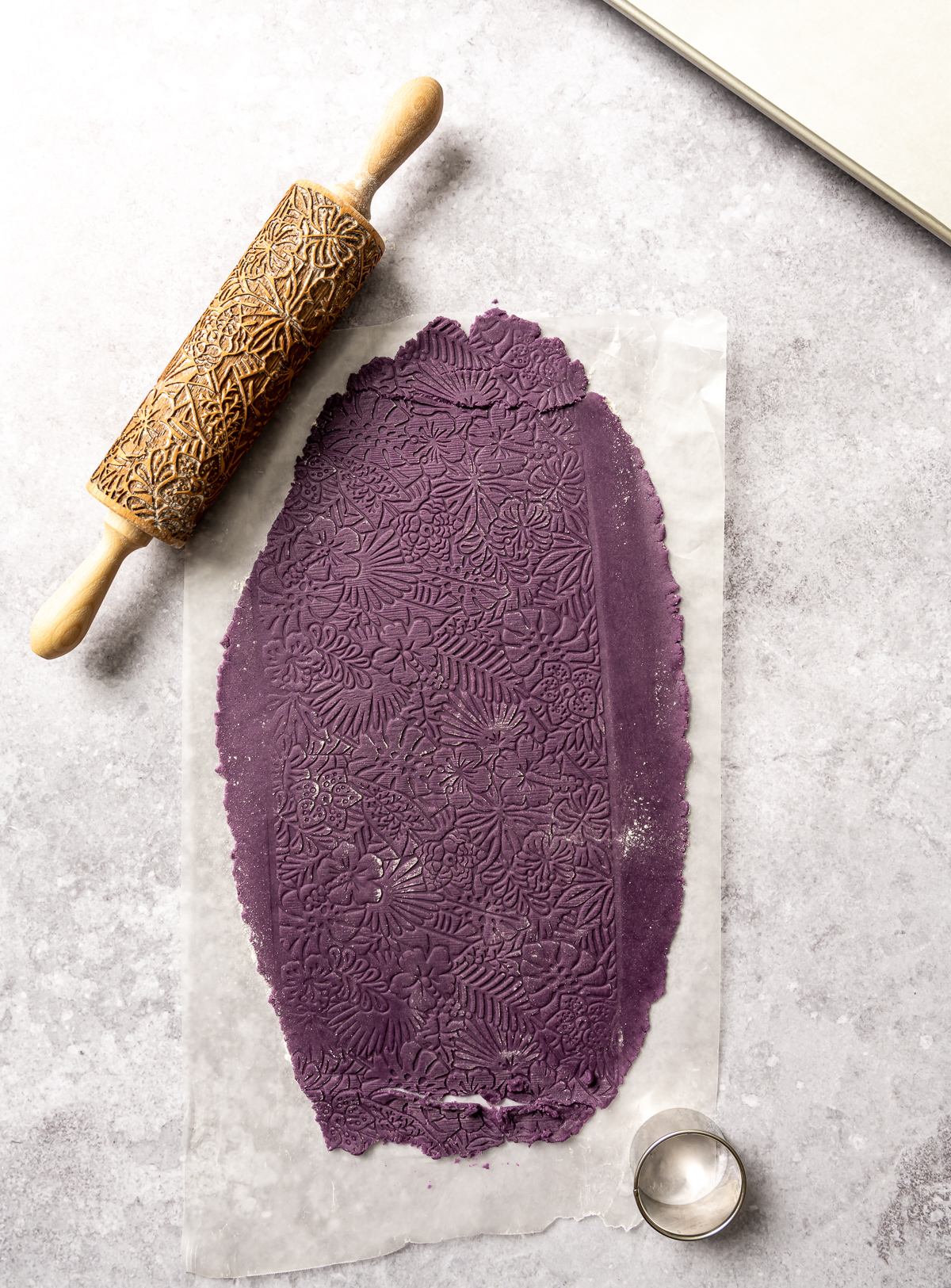 purple cookie dough rolled out and embossed tropical flower embossing roller