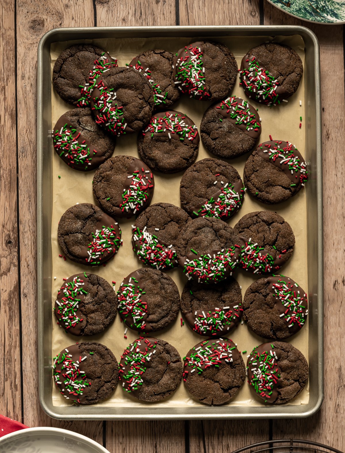 chocolate gingerbread cookies with red green and white sprinkles on a baking tray