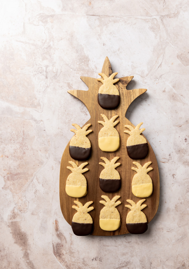 Pineapple shaped cookies on a pineapple shaped wood board