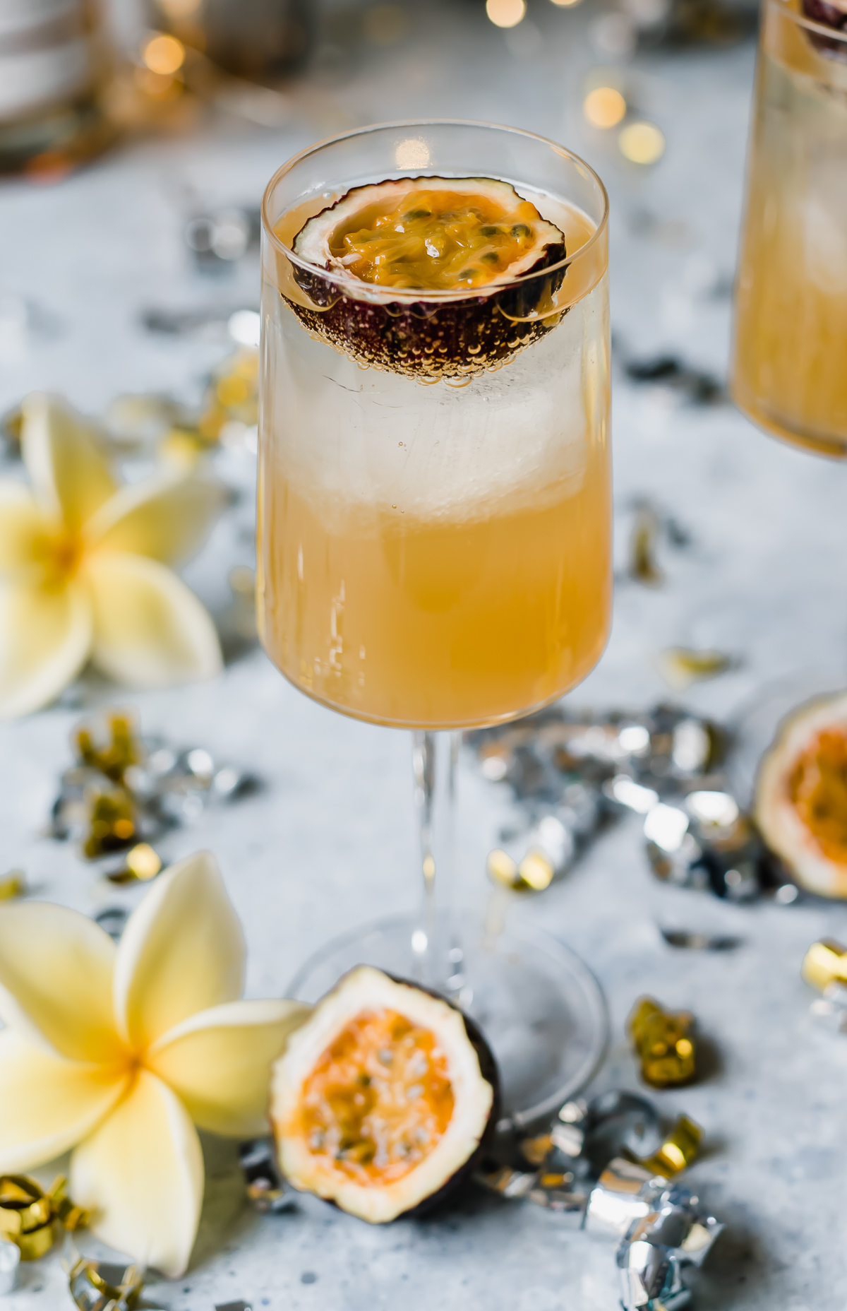 Sweet and sour passionfruit rum fizz cocktail orange liquid in glass with passionfruit half