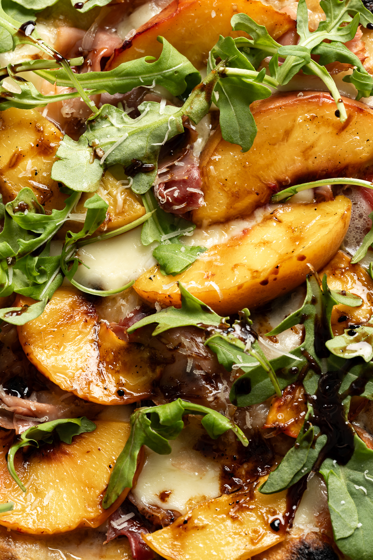 grilled peach pizza with prosciutto mozzarella arugula balsamic glaze parmesan cheese