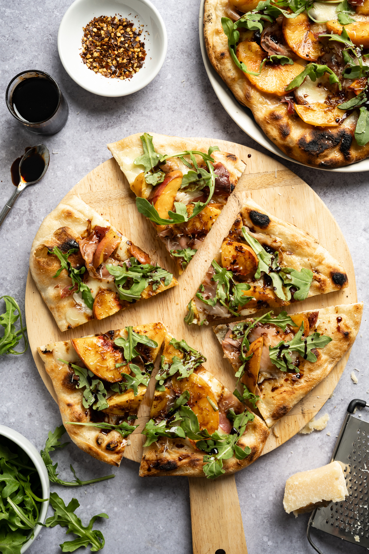 grilled peach pizza with prosciutto mozzarella arugula balsamic glaze parmesan cheese