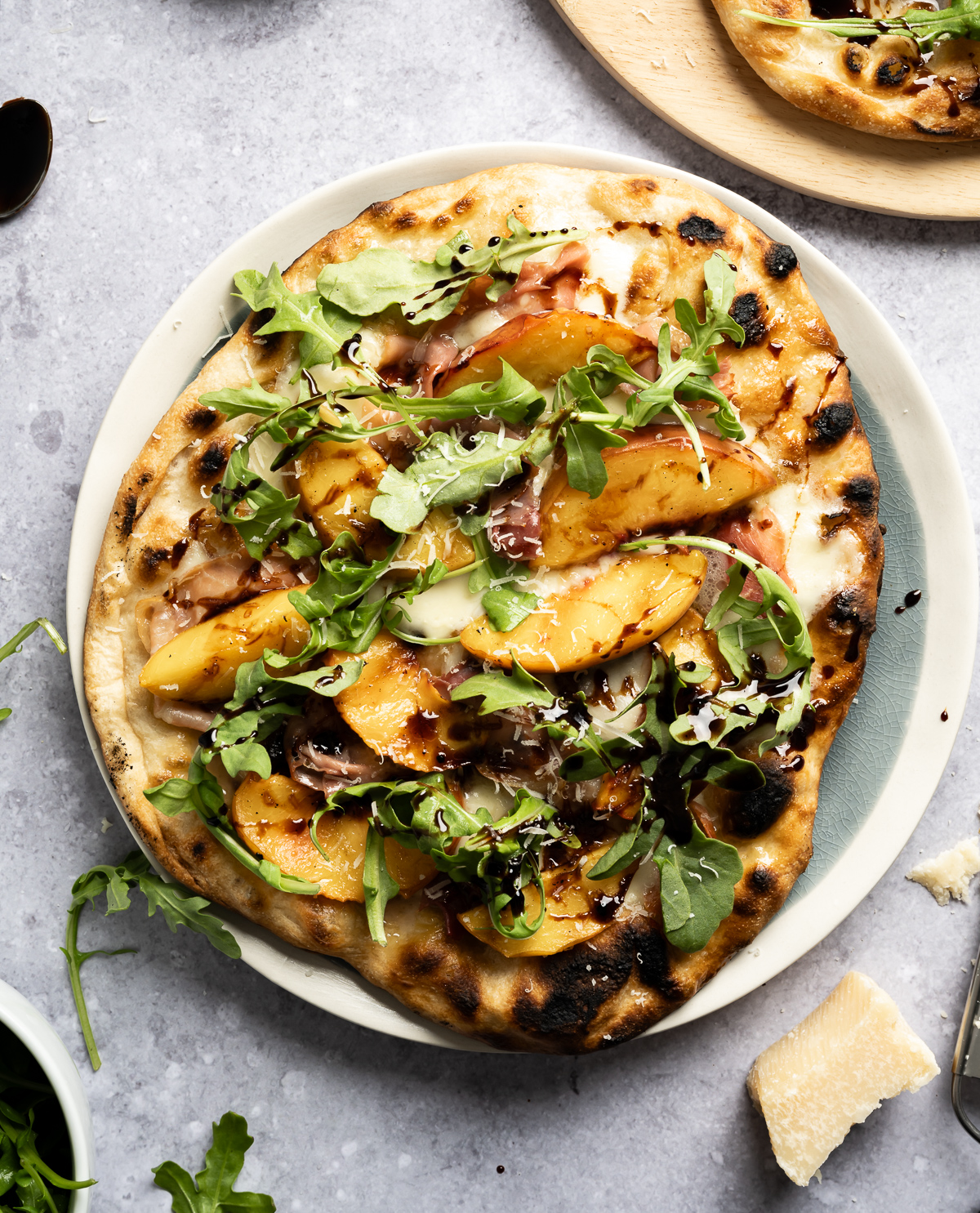 grilled peach pizza with prosciutto mozzarella arugula balsamic glaze parmesan cheese