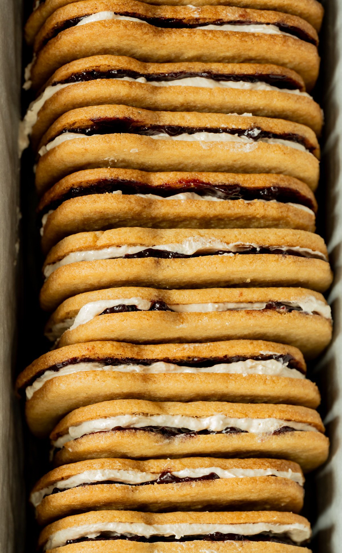 filled sandwich cookies line up on their sides in a tin