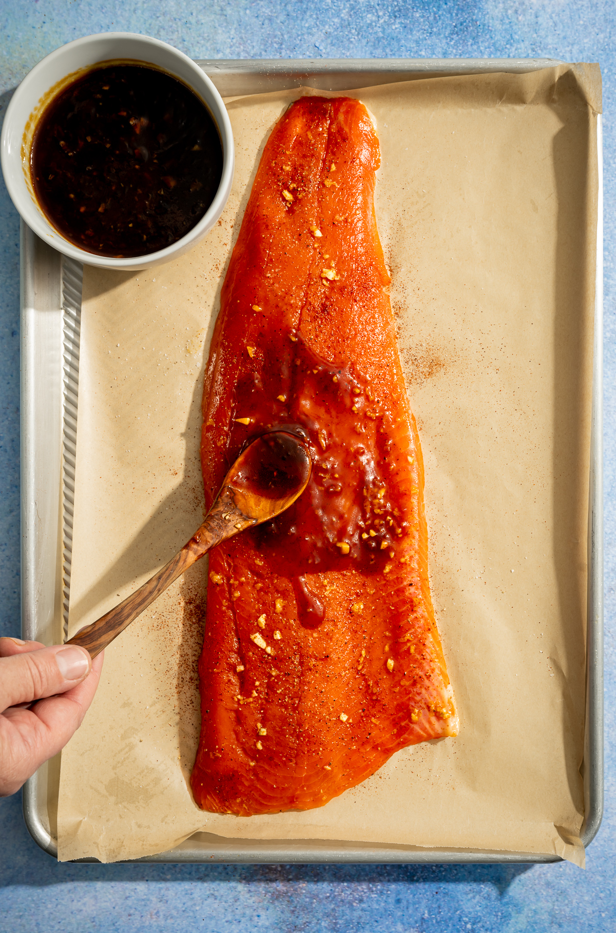 hot honey glaze being spooned over a salmon fillet