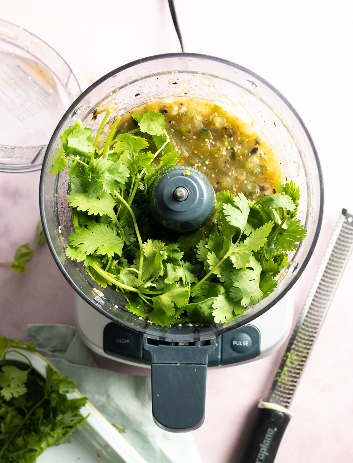 chunky pureed green salsa in food processor with cilantro