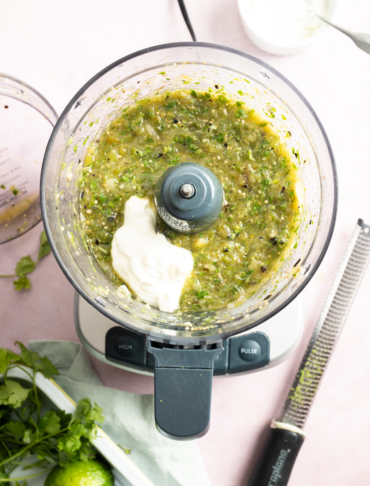 chunky pureed green salsa in food processor with sour cream