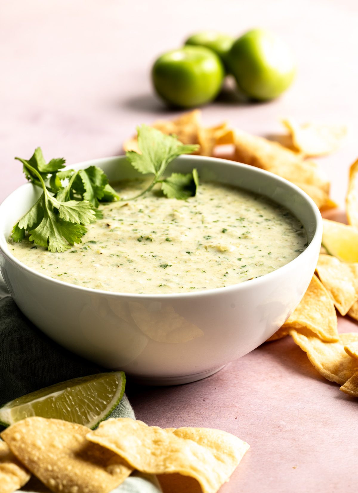 bowl of green salsa with cilantro limes chip