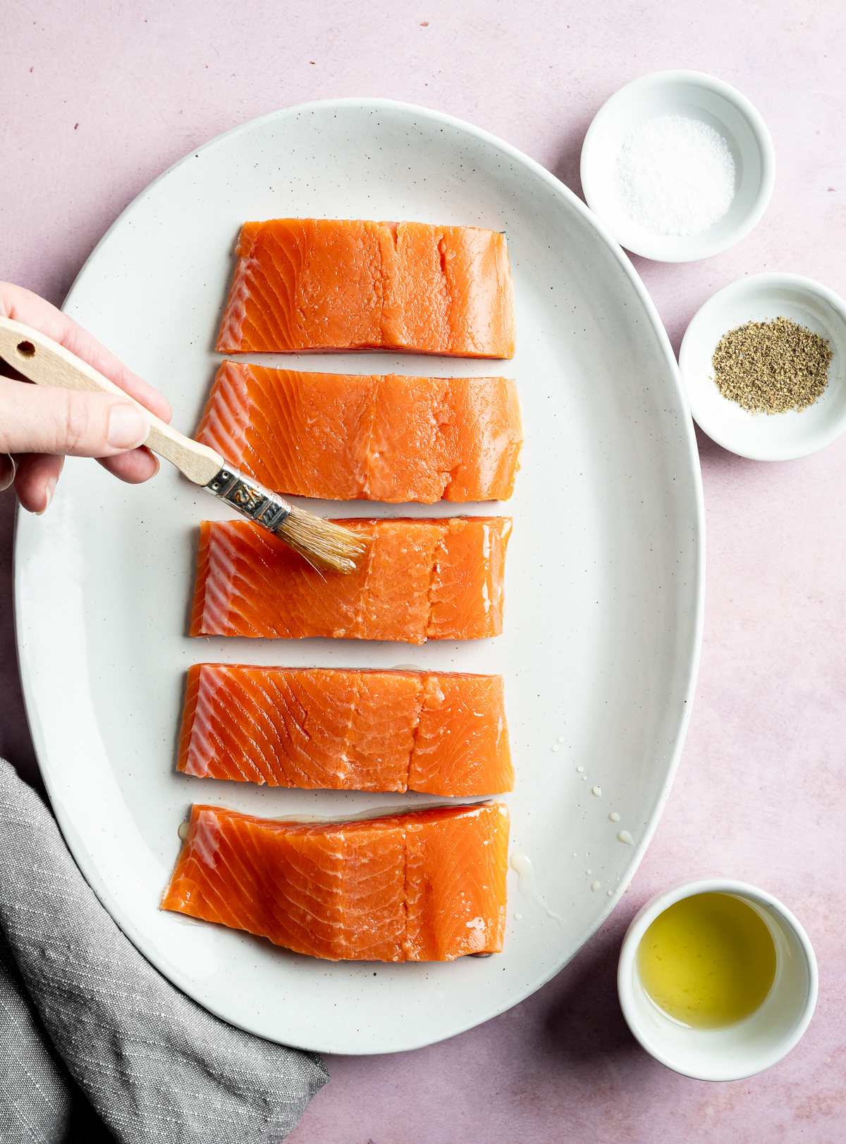 oil being brushed on salmon fillets