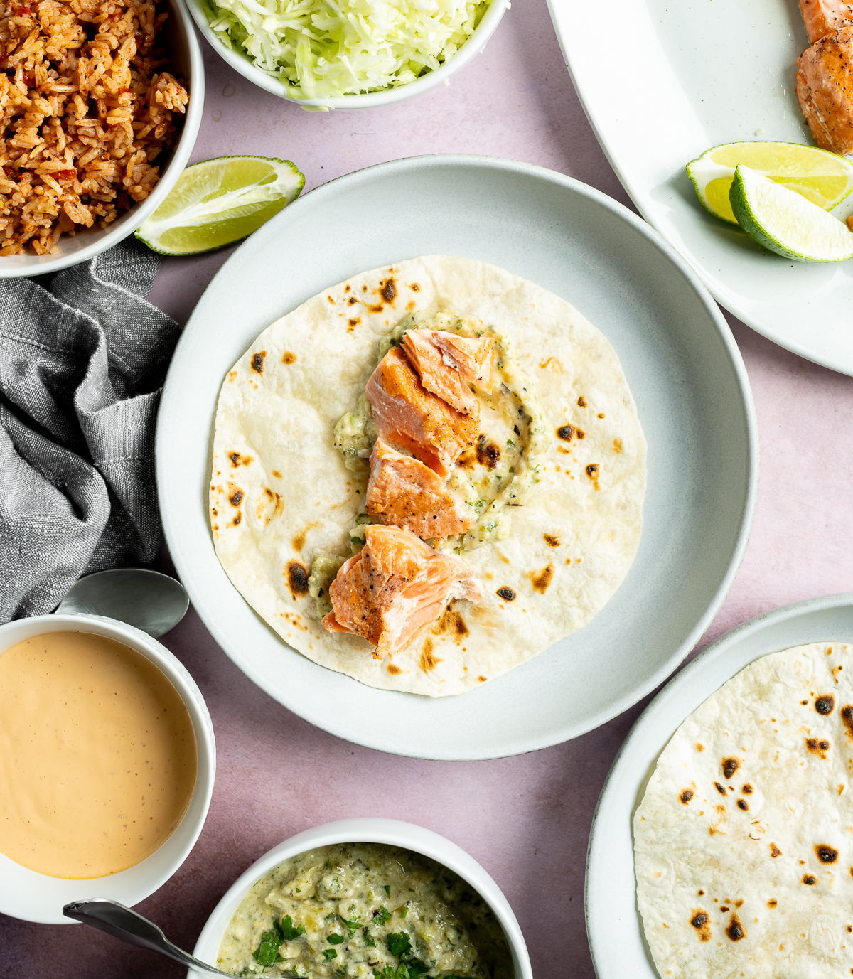 salmon on top of green salsa on a tortilla on a light blue plate