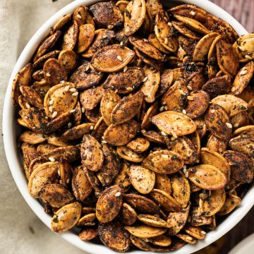 brown roasted pumpkin seeds in white bowl