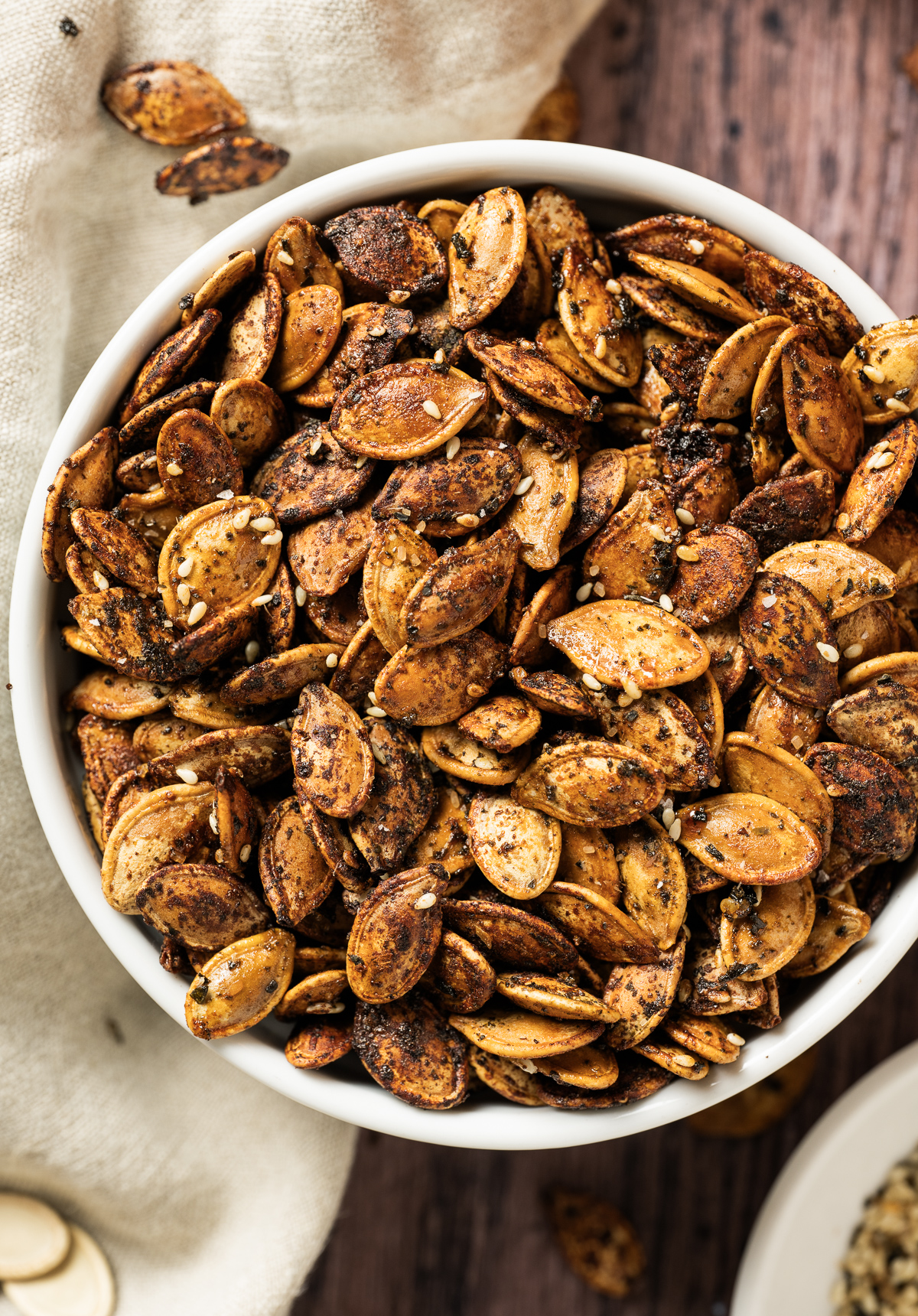 brown roasted pumpkin seeds in white bowl