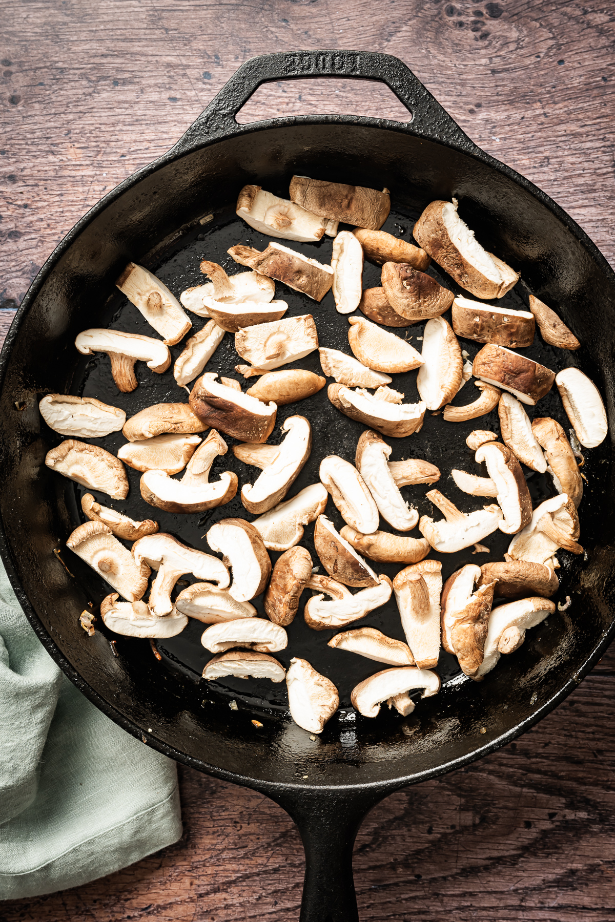sliced fresh shiitake mushrooms in cast iron pan