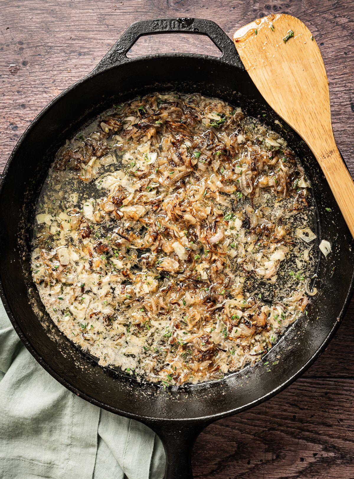 caramelized shallots chopped fresh thyme with sliced garlic and melted butter in cast iron pan