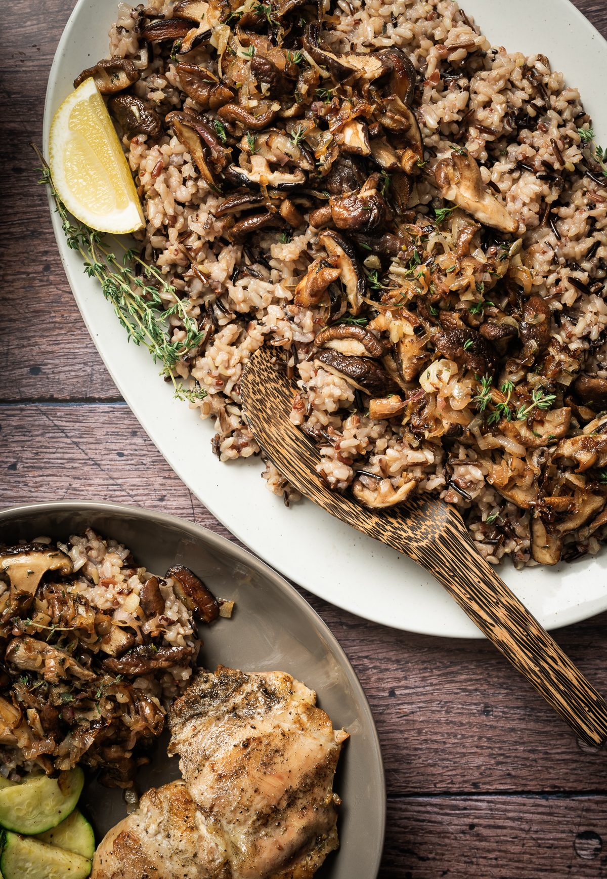 large platter with wild rice and sauteed mushrooms lemon wedge fresh thyme