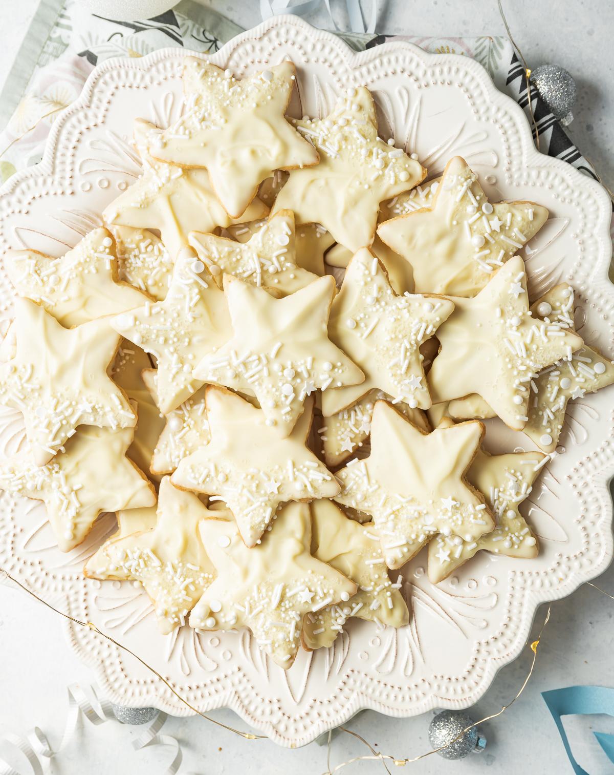 star shaped white chocolate dipped cardamom shortbread cookies on a white plate