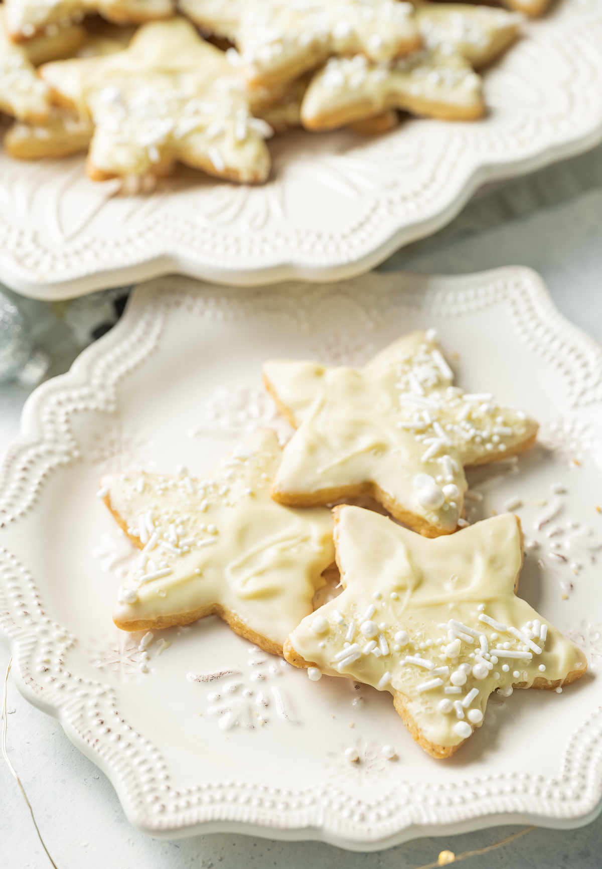 star shaped white chocolate dipped cardamom shortbread cookies on a white plate