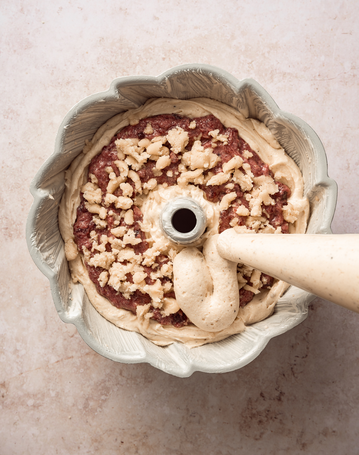 bater being piped into a bundt cake pan